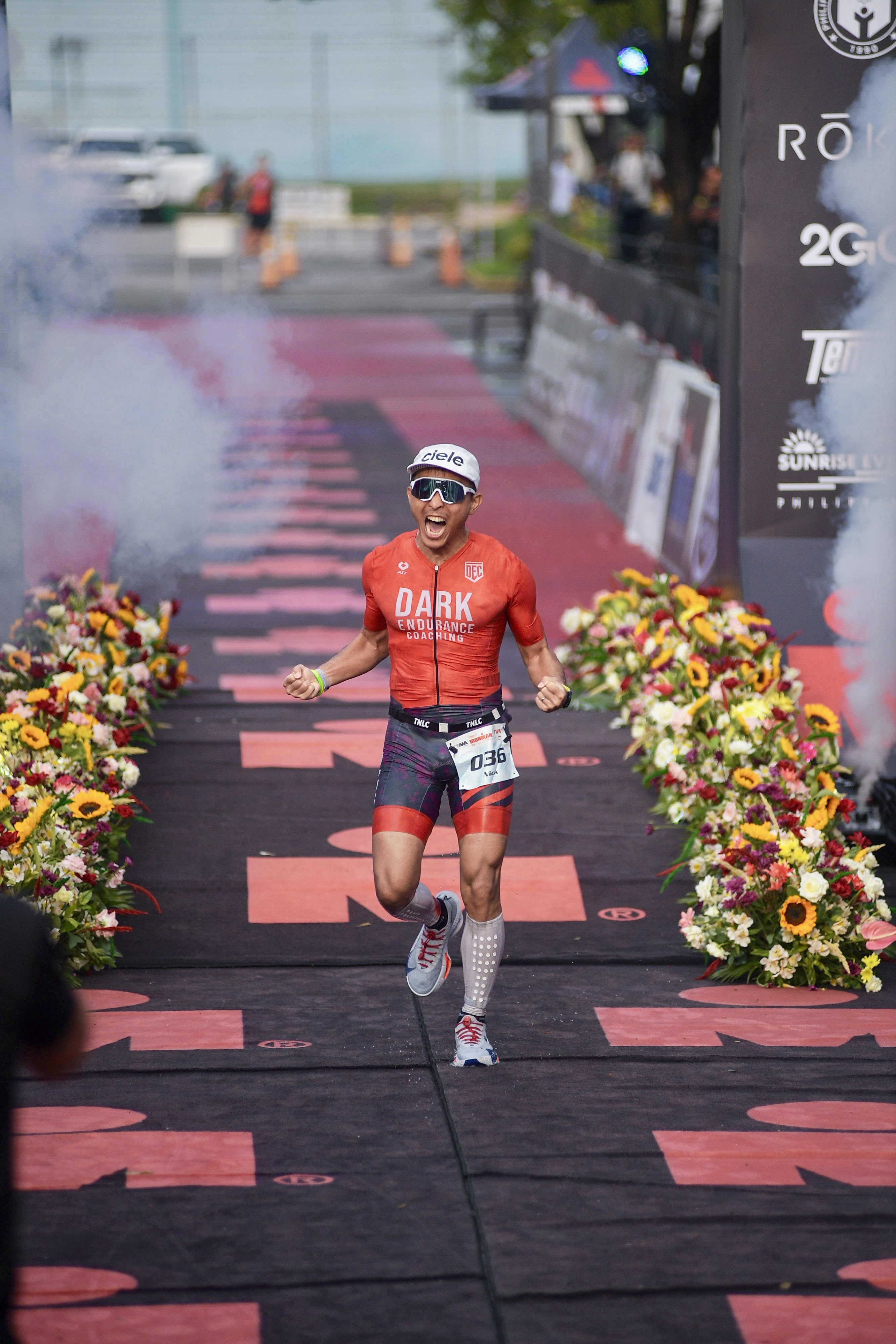 Nick Hsieh crossing the finish line at IRONMAN Philippines 2026, bib 036